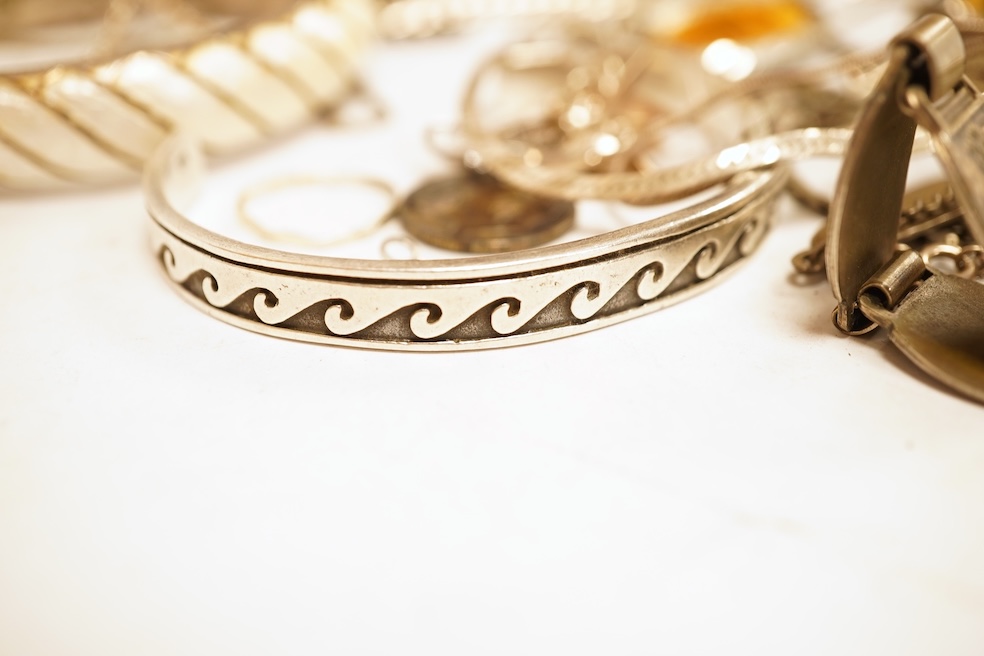 A small group of silver and white metal jewellery including Siamese enamelled bangle, silver chain, drop earrings, Persian coin brooch, etc.